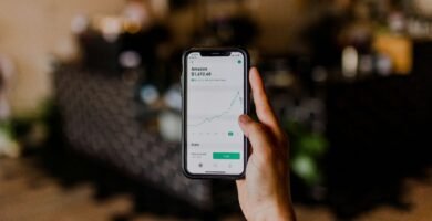 person holding black iPhone displaying stock exchange