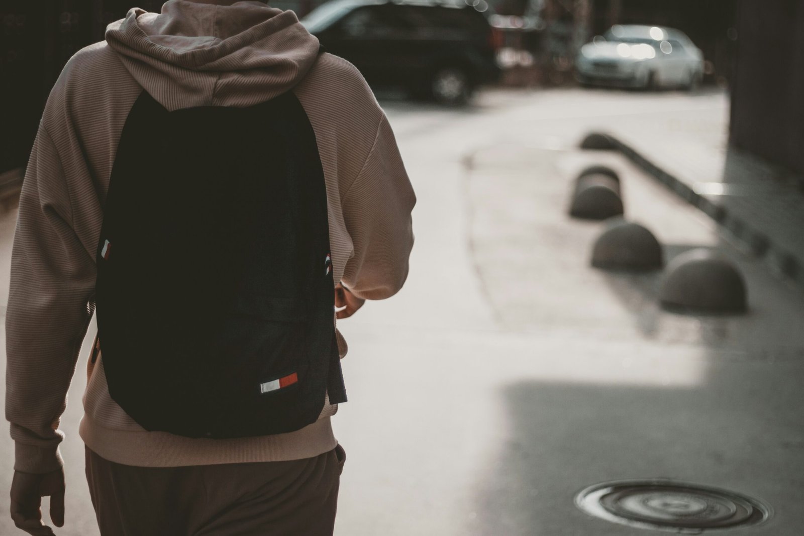 a man walking down a street with a backpack on his back